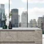 Bei einer skandinavisch inspirierten Renovierung sollte die Küche mehr sein als nur ein Ort zum Kochen – sie wird zum Rückzugsort, Treffpunkt und Ausdruck durchdachten Designs. Beginnen Sie mit einer neutralen Basis, ergänzt durch natürliche Materialien und Strukturen. Fügen Sie grifflose Schränke und offene Regale hinzu, um Schlichtheit und Offenheit zu unterstreichen, während persönliche Akzente wie Keramikgeschirr, Glas oder Pflanzen für Individualität sorgen. Die Wahl der richtigen Arbeitsplatte definiert die Atmosphäre entscheidend. Mit Caesarstone Keramik und Quarzkomposit Oberflächen erreichen Sie die perfekte Balance aus Licht, Struktur und Tonalität – und Ihre Küche vereint modernen Luxus mit zeitloser nordischer Eleganz. Ob Sie klare, helle Designs bevorzugen oder die subtile Wärme von steininspirierten Varianten – die richtige Oberfläche macht Ihre Vision lebendig. Die Suche nach Ihrer Traum-Arbeitsplatte ist ganz einfach: In den Showrooms unserer Partner finden Sie großformatige Ausstellungen der aktuellen Caesarstone Kollektionen.