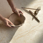 Caesarstone ICON 8251 Taj Whisper white surface with hands and bowl