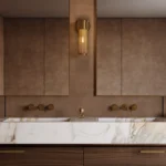 Modern bathroom with dual mirrors, brass fixtures, marble countertop, and wooden cabinetry.
