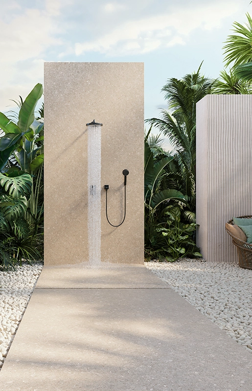 Caesarstone Porcelain 546 Thalassa in Outdoor shower area with plants, stone flooring, wooden vanity, round mirror, and copper sink.